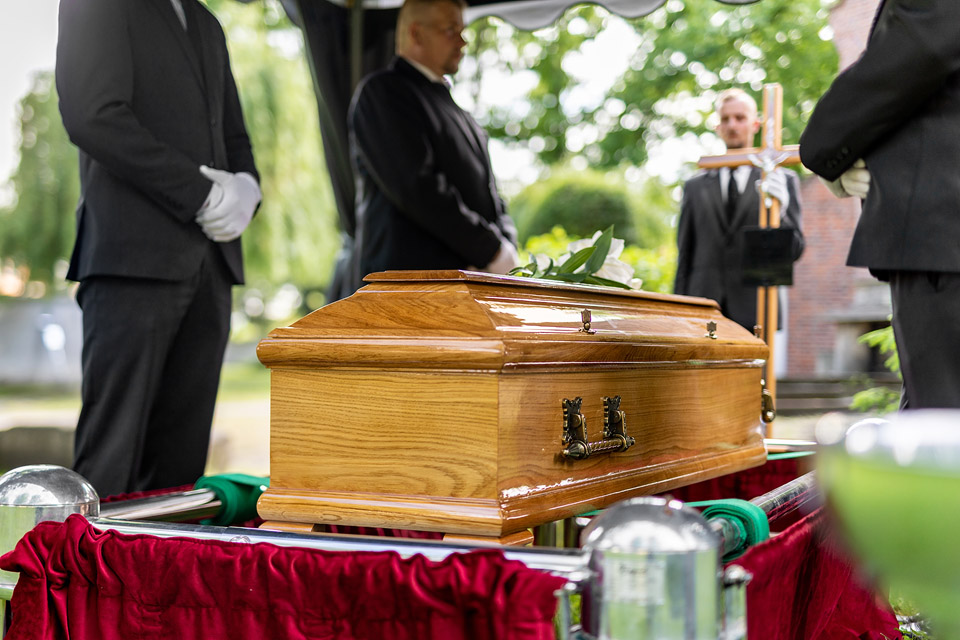 Pracownicy firmy Archon podczas ceremonii pogrzebowej, trumna w kaplicy.